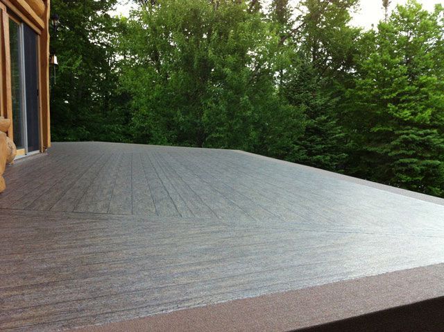 Une terrasse en membrane de pvc avec des arbres en arrière-plan
