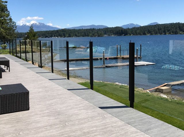 Une vue sur un lac depuis une terrasse avec une clôture en verre