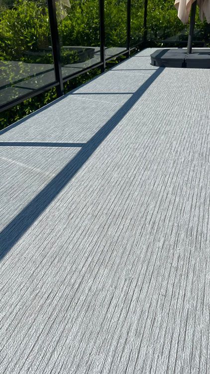 Un gros plan d'une membrane de pvc sur un balcon avec une balustrade en verre.