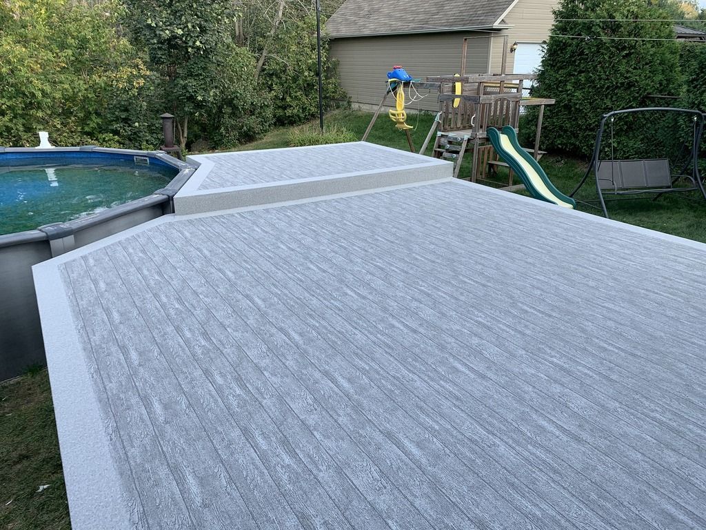 Une terrasse en pvc à côté d'une piscine dans une cour arrière.