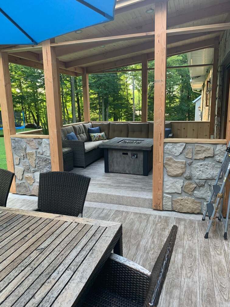 Un patio avec une table et des chaises et un foyer.