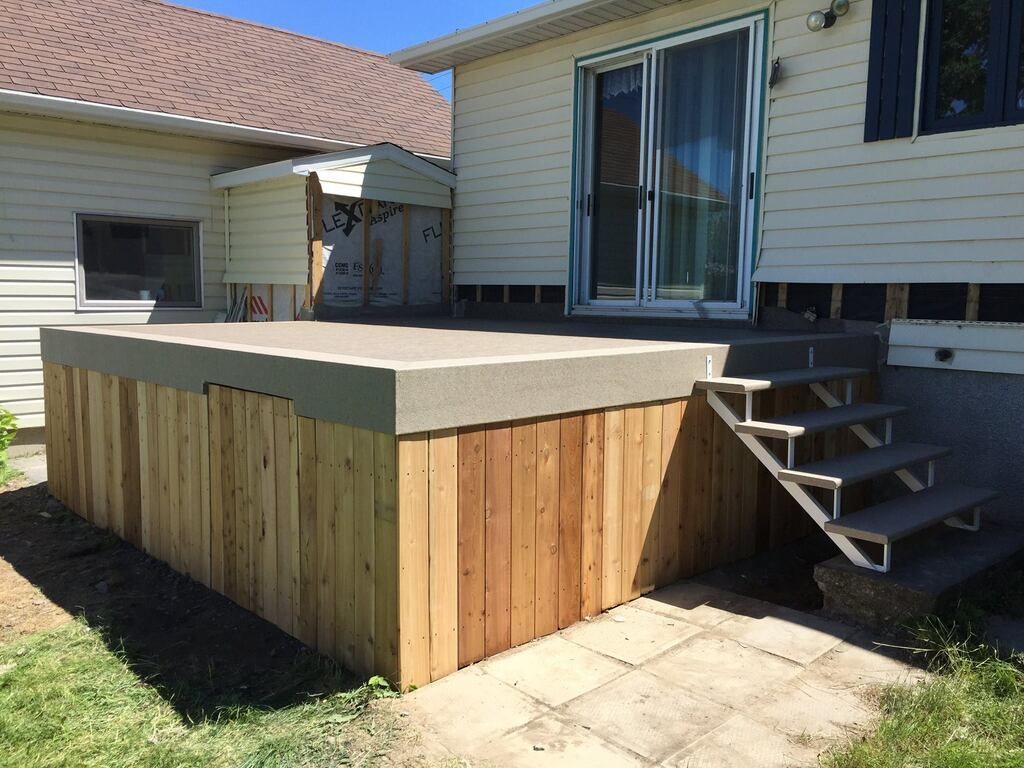 Une maison avec une terrasse en pvc et des escaliers devant elle