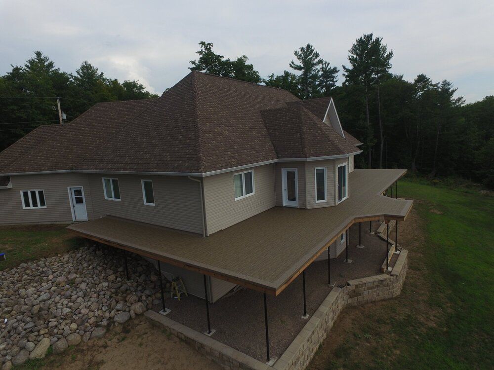 Une vue aérienne d'une grande maison avec un grand porche entouré d'arbres.