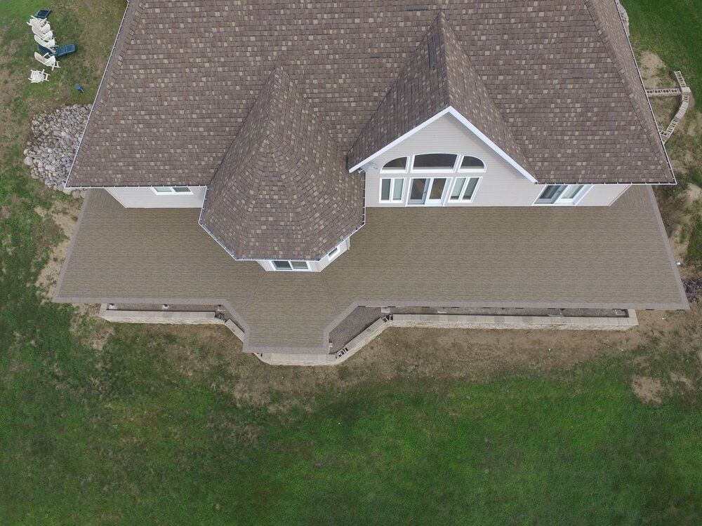 Une vue aérienne d'une maison avec un grand patio devant.