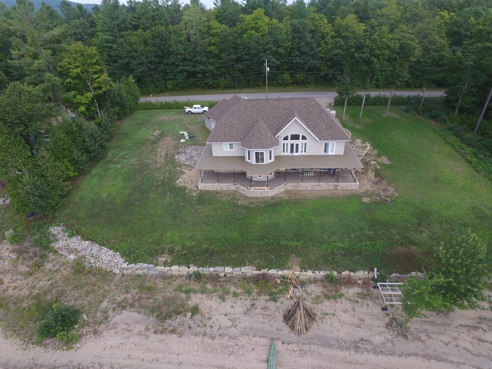 Une vue aérienne d'une maison au milieu d'un champ verdoyant.