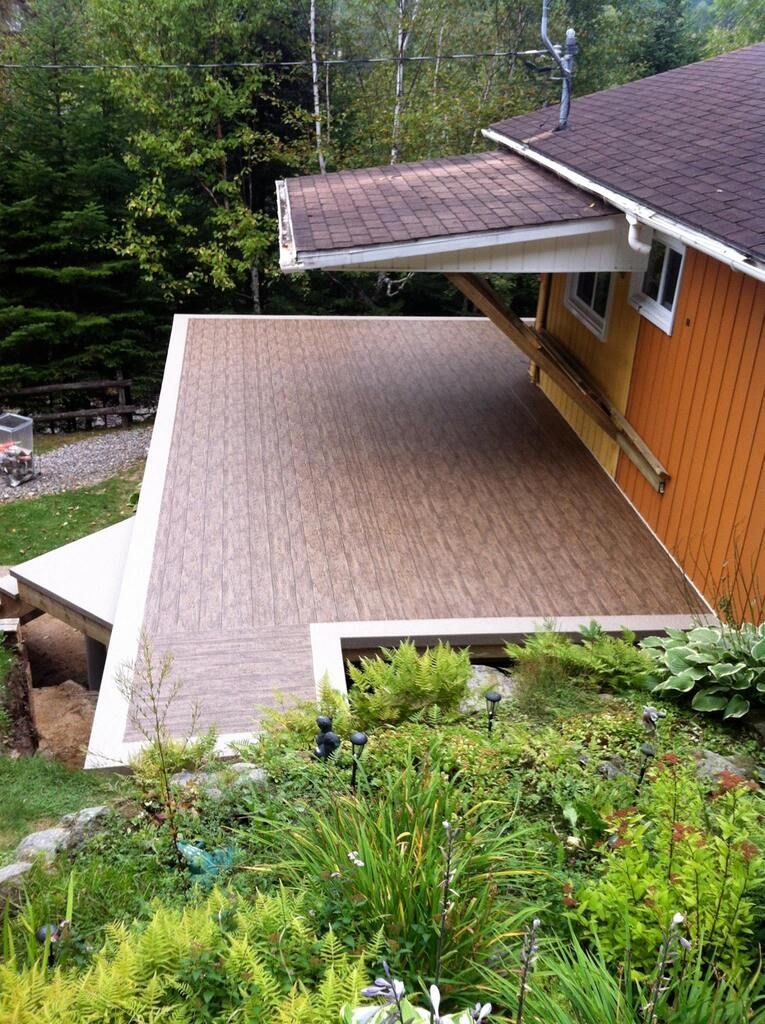 Une maison avec un patio en pvc sur le côté