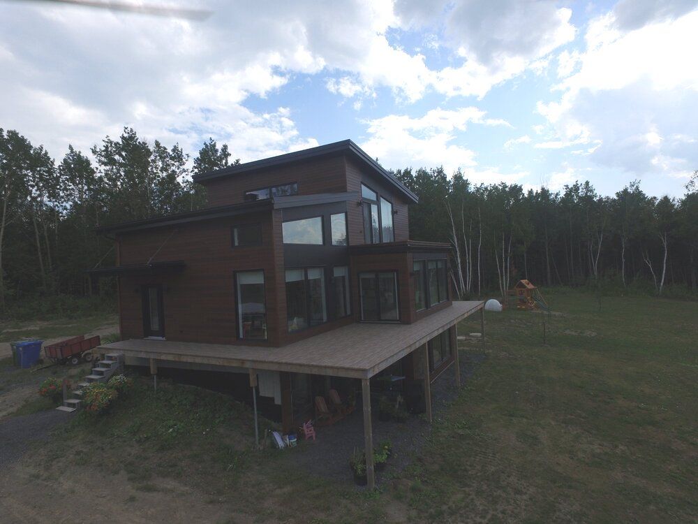 Une vue aérienne d'une maison au milieu d'un champ avec grande terrasse