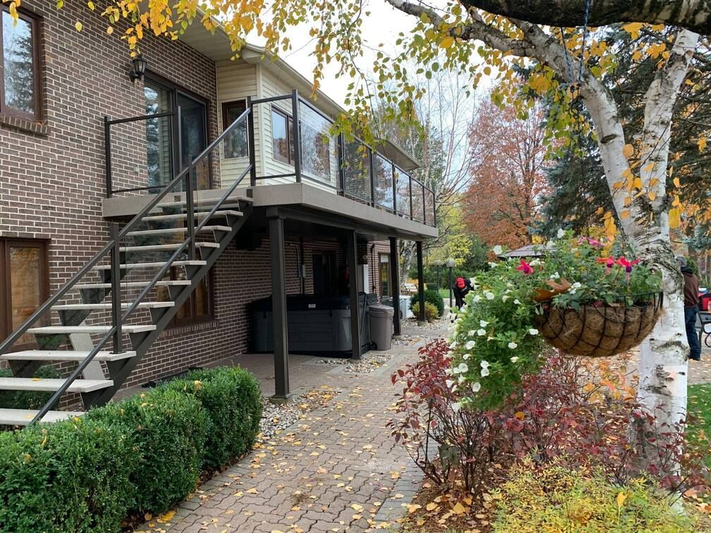 Une maison en brique avec des escaliers menant à une terrasse.