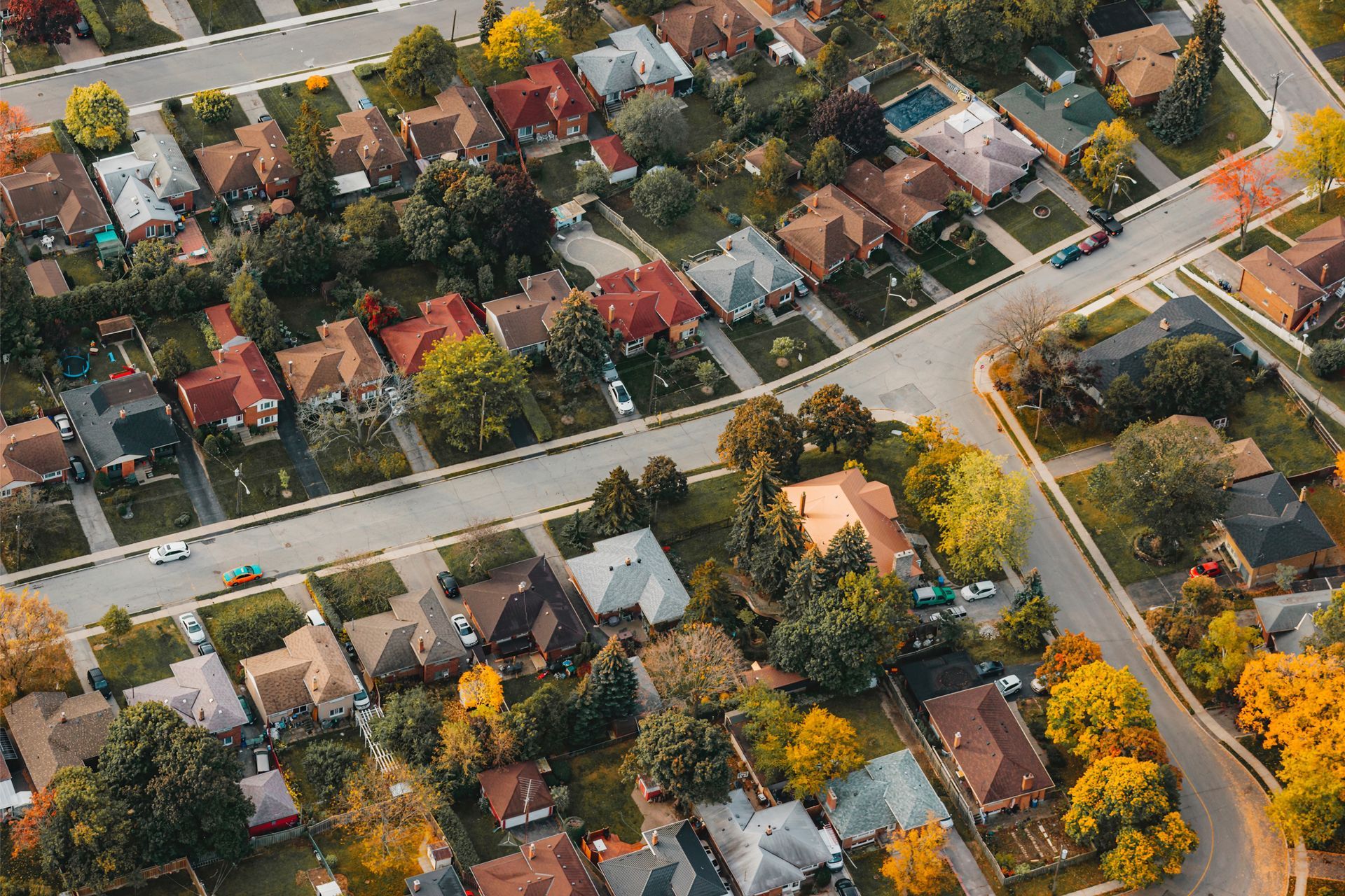 Vue aérienne d'un quartier résidentiel de banlieue avec des maisons, des rues et des arbres.