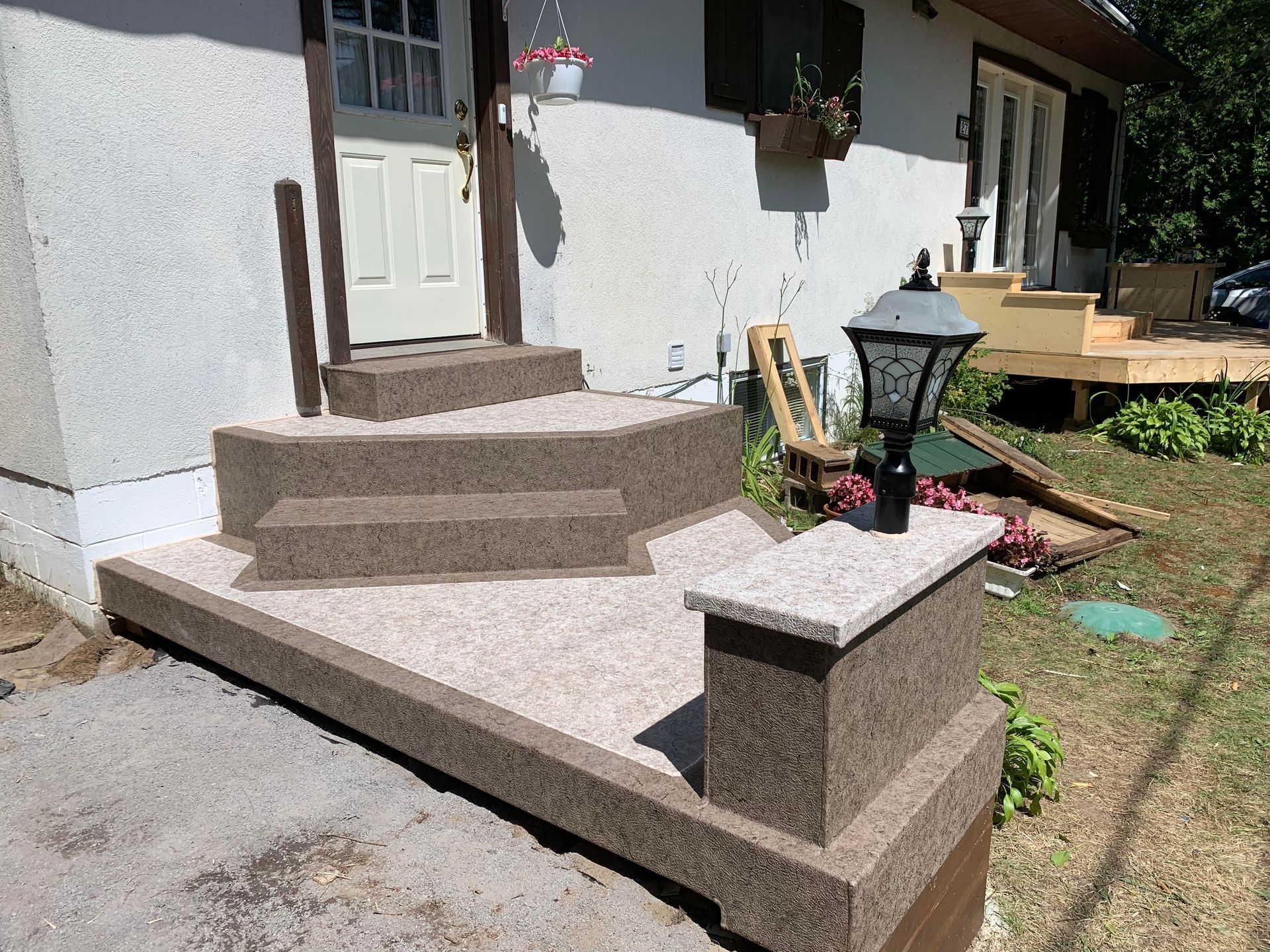 Une maison avec des escaliers et un lampadaire devant.