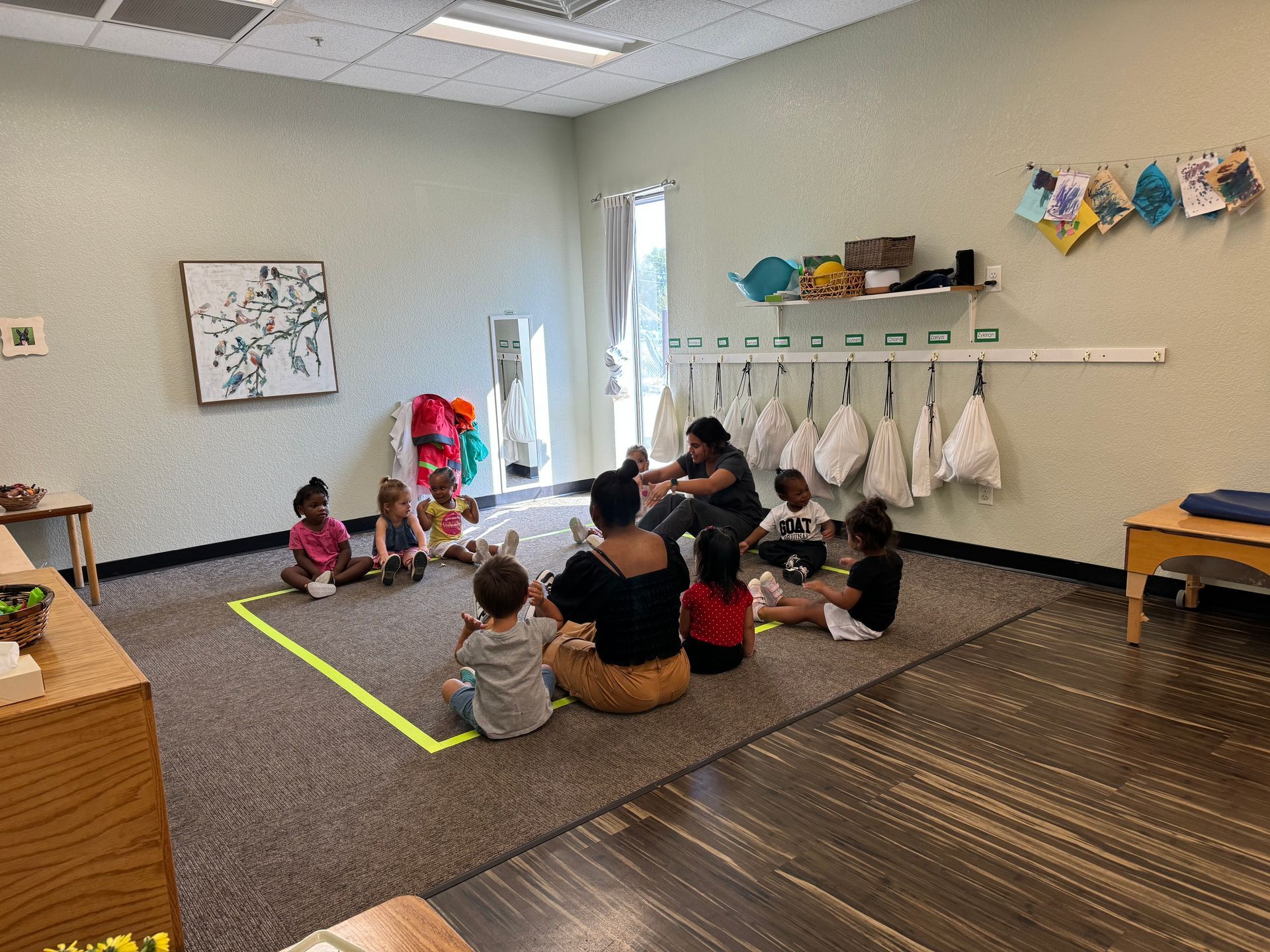 A group of children are sitting on the floor in a room.