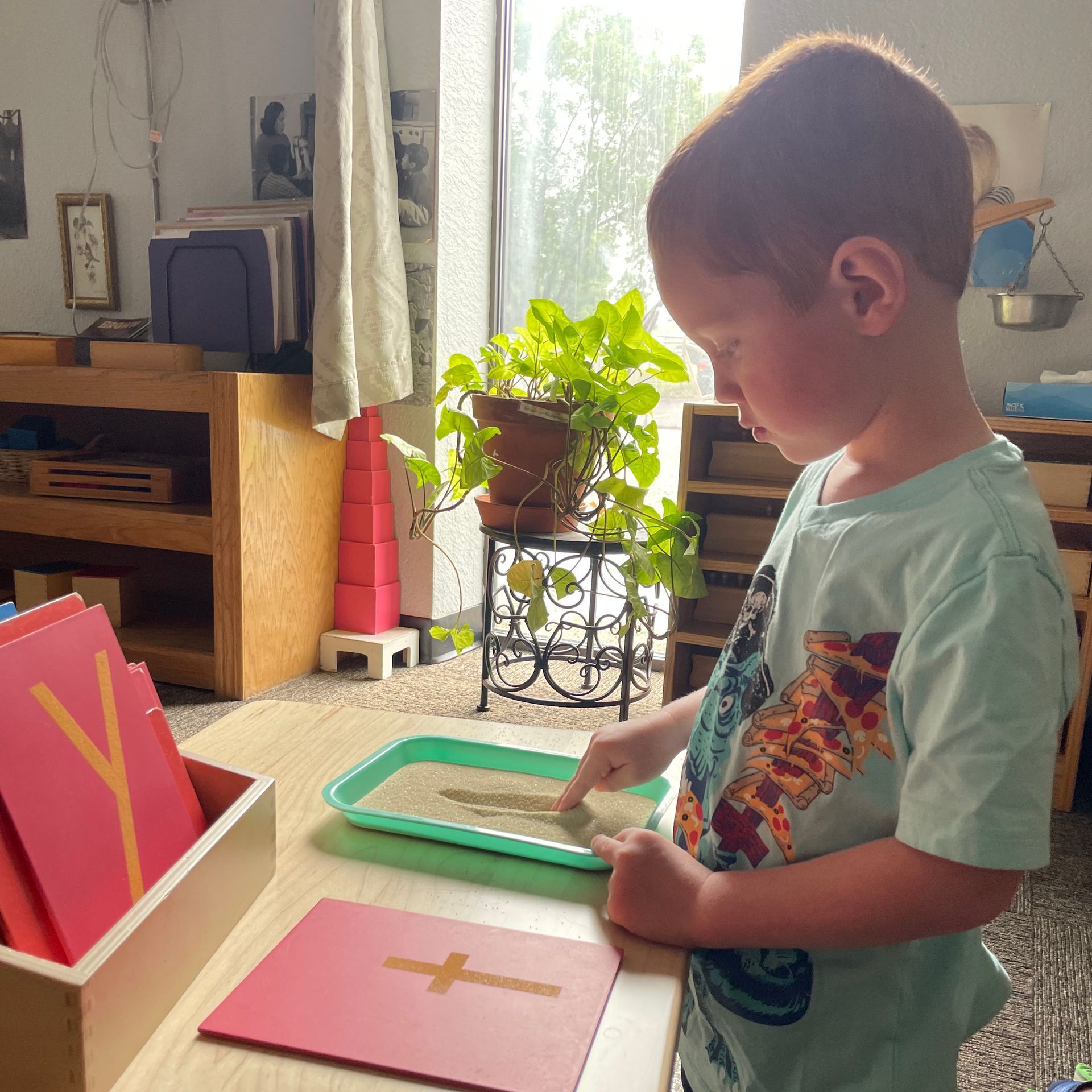 A young boy is playing with sand on a table