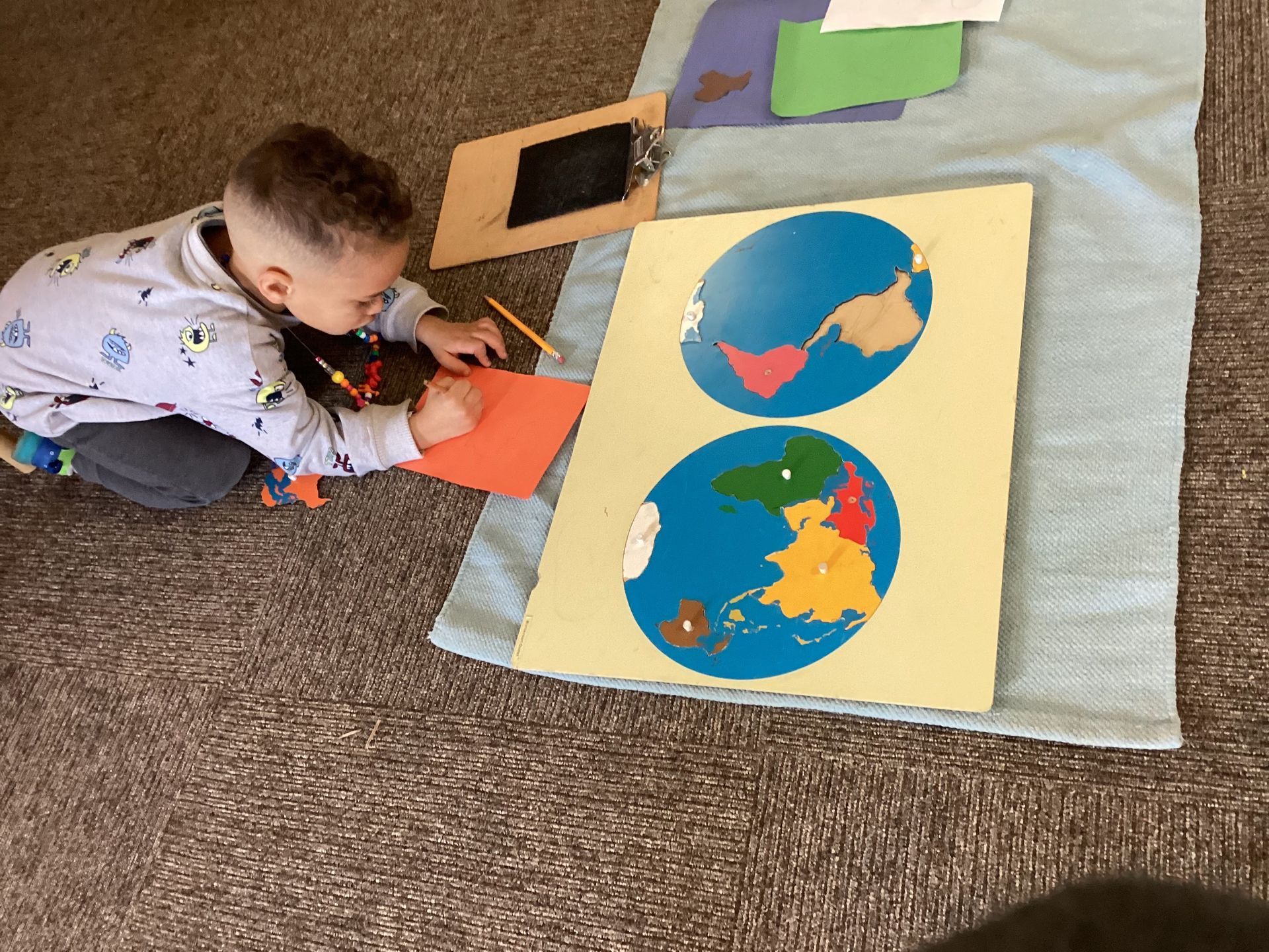 A young boy is playing with a map of the world