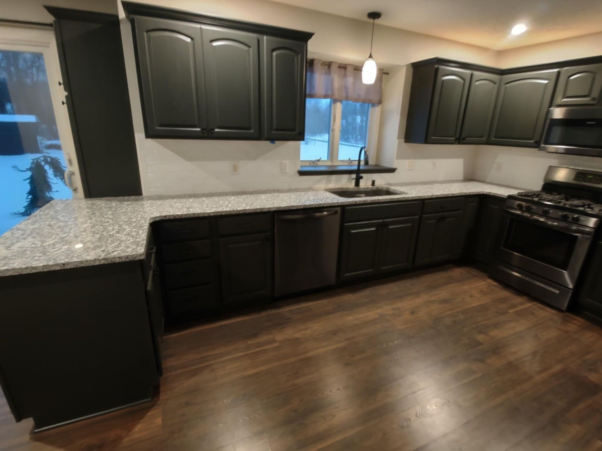 A kitchen with black cabinets and granite counter tops