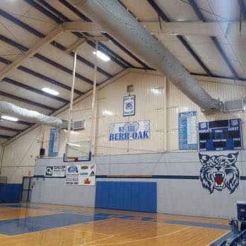 Interior of a basketball gym. Features blue and white wall with 