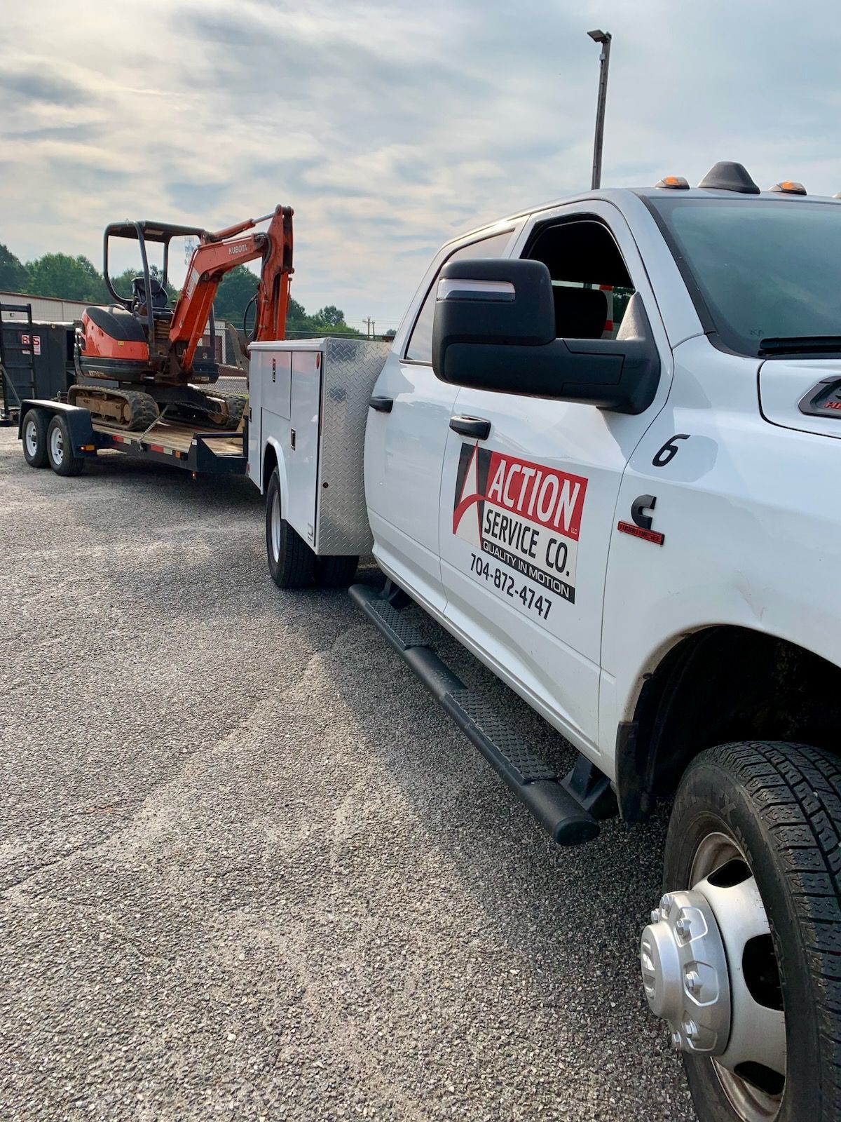 Person using a camera to inspect a sewer, with equipment nearby, in a concrete room.