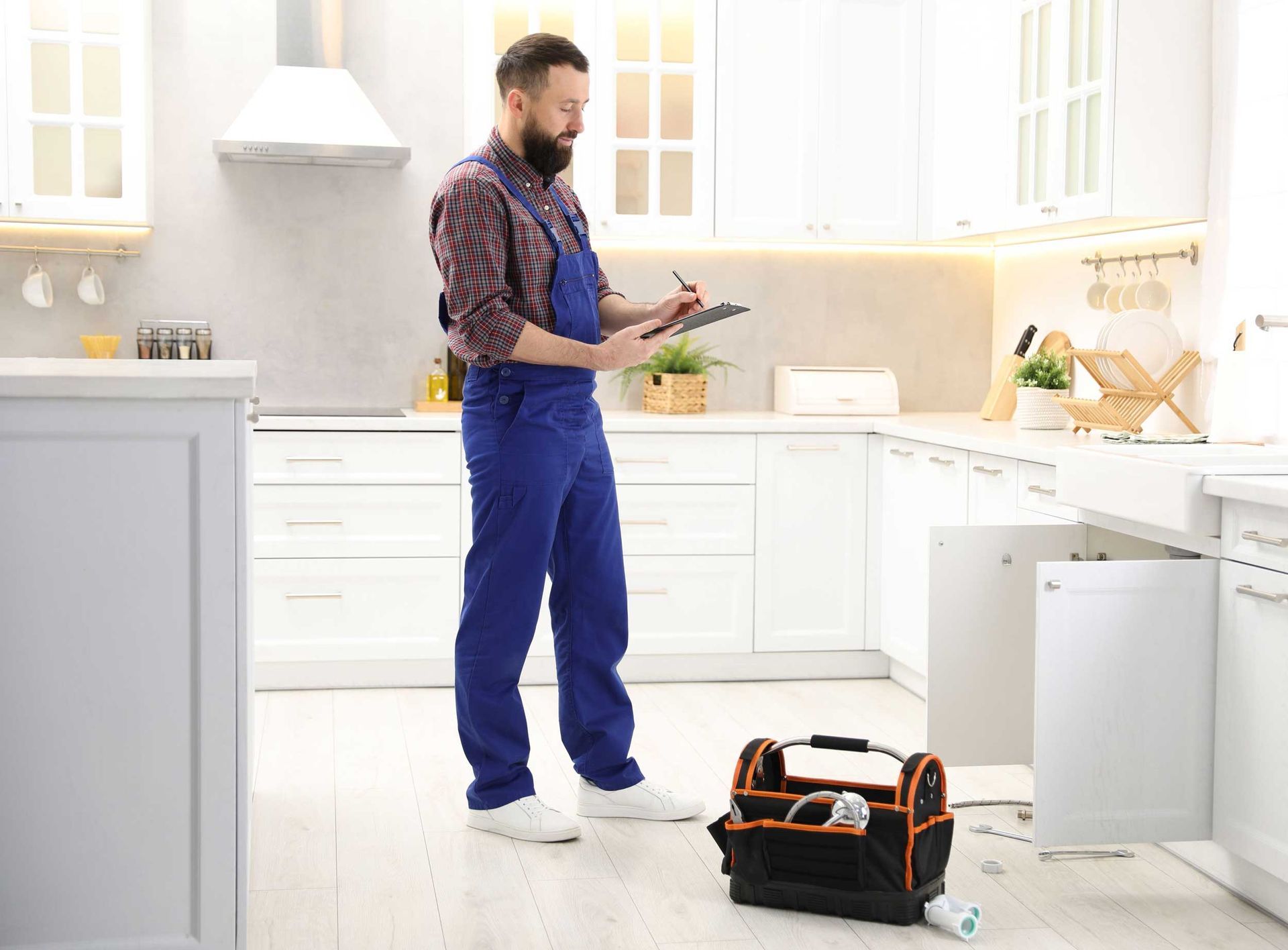 Plumbing repair contractors are inspecting the kitchen plumbing system.