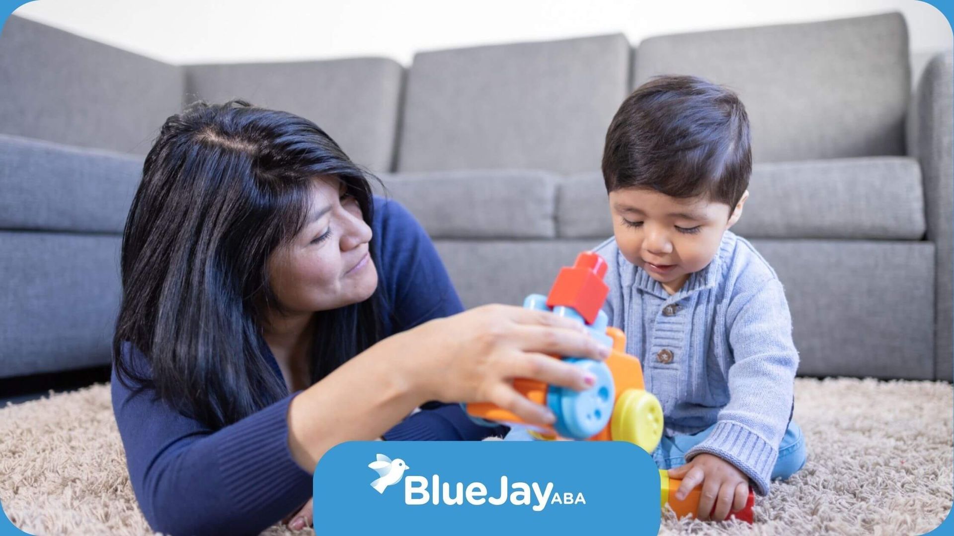 Mother playing with toddler using colorful toy blocks during ABA therapy at home.
