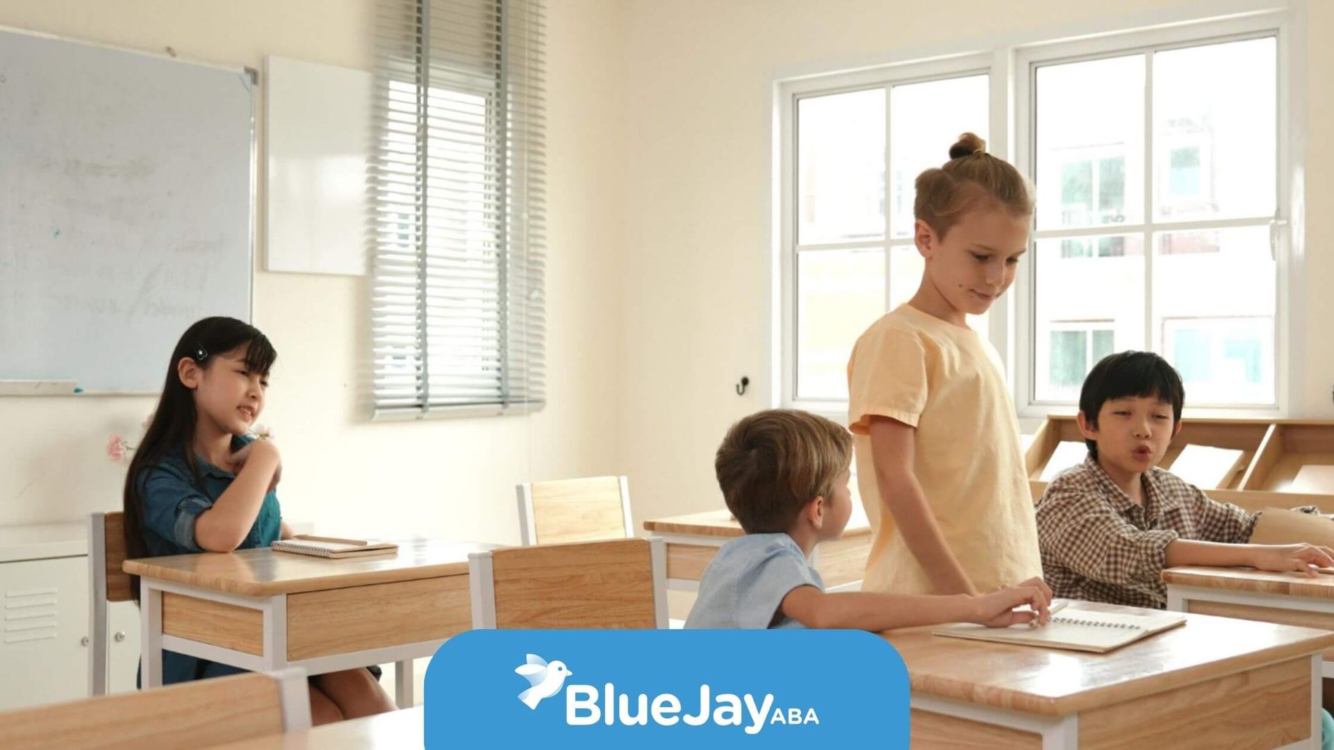 Group of children with autism talking together in a bright classroom.
