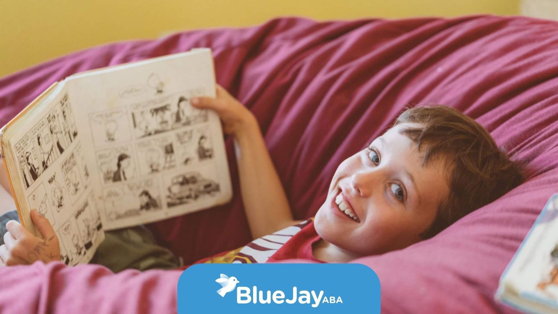 Boy with autism reading comic on beanbag.