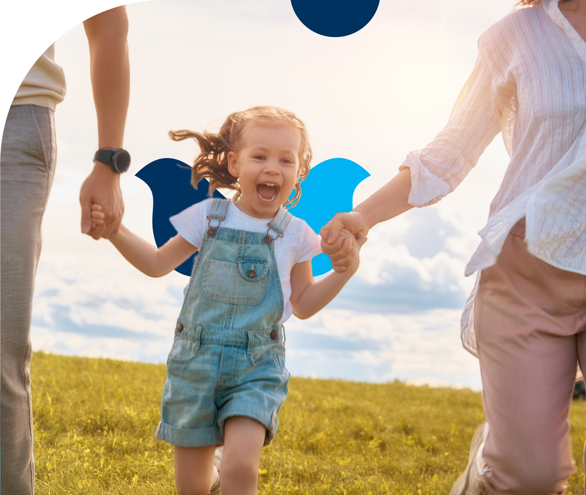 A family is holding hands and running in a field.