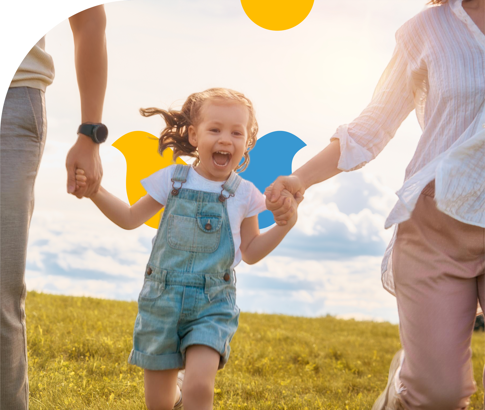 A family is holding hands and running in a field.