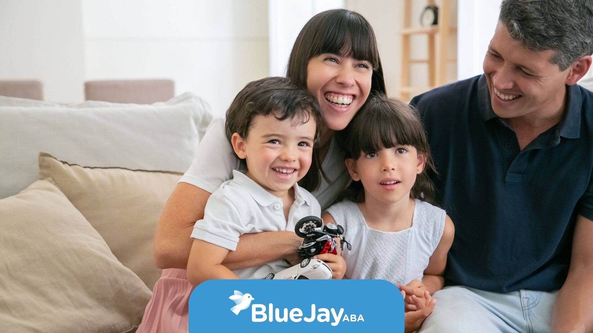 Family laughing on the couch in ABA therapy.