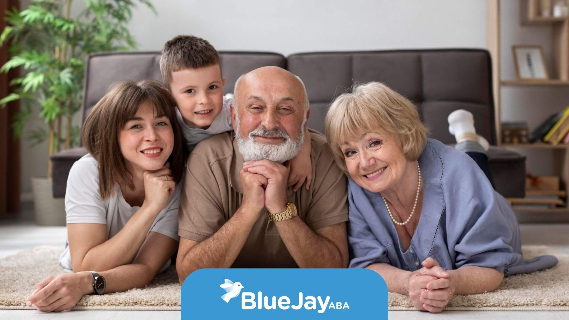 Happy family of four lying on the floor, smiling together.