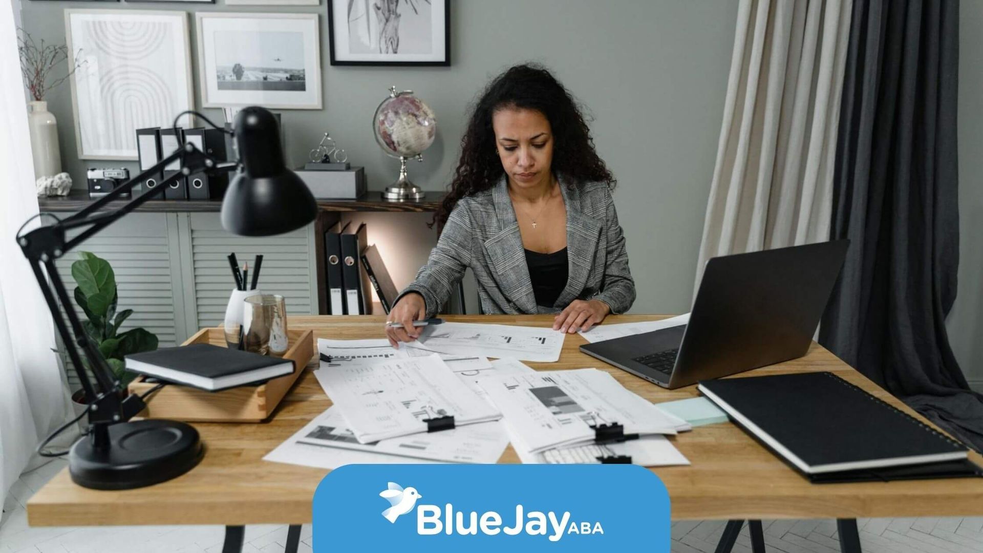 An ABA therapist working at a desk covered with papers and a laptop in the office in North Carolina