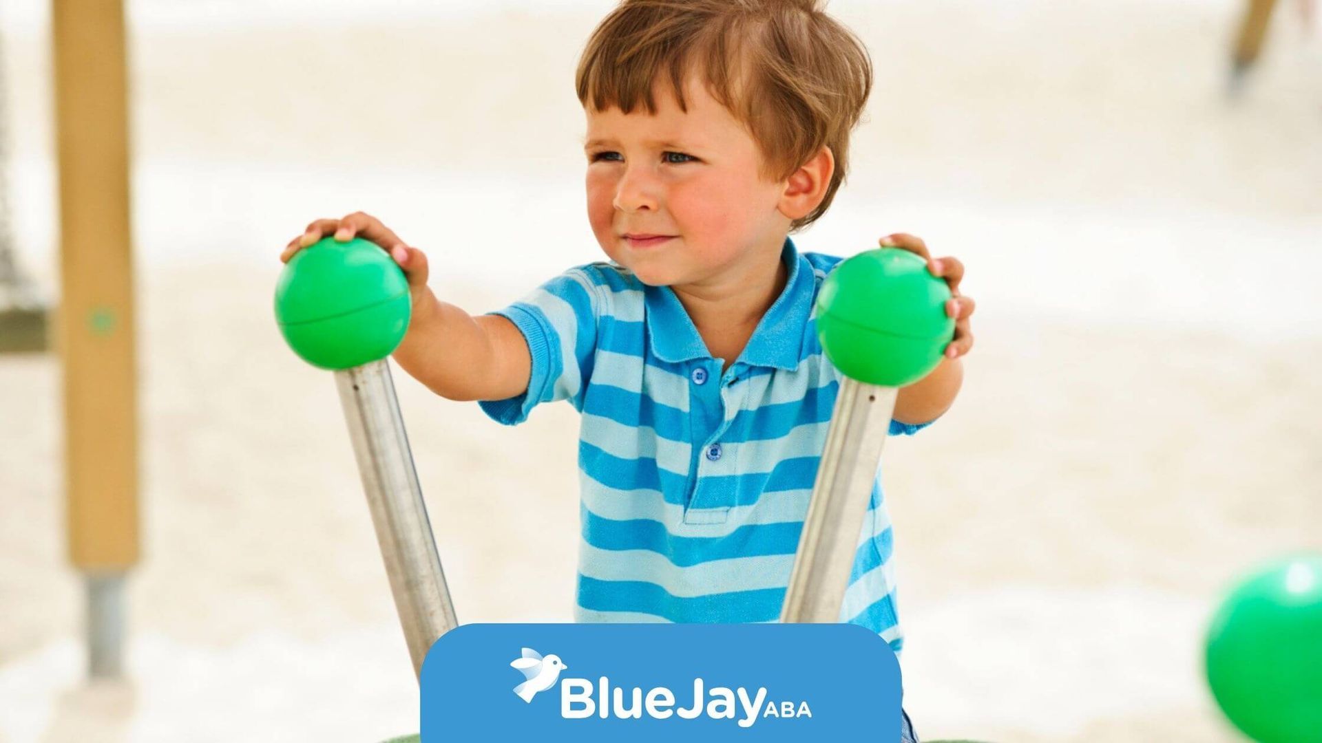 Toddler with autism playing on beach playground equipment.