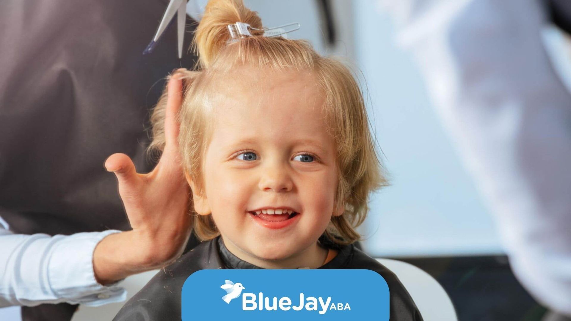 A child with autism smiling during a haircut.