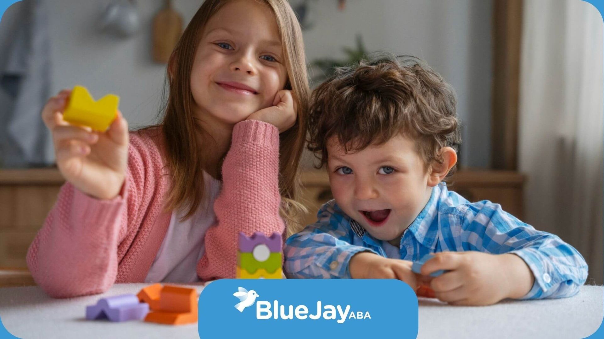 A boy and a girl with autism are playing with blocks at a table in ABA therapy.