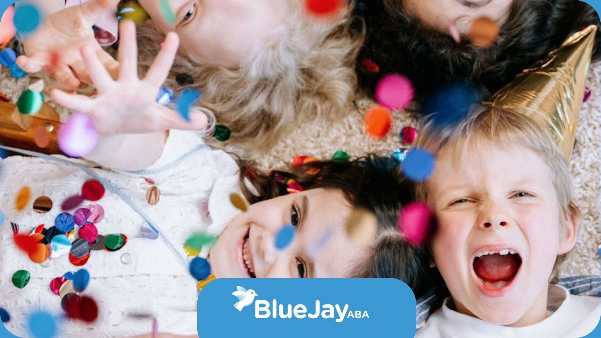 Autistic children lying on the floor throwing colorful confetti with big smiles in Massachusetts.