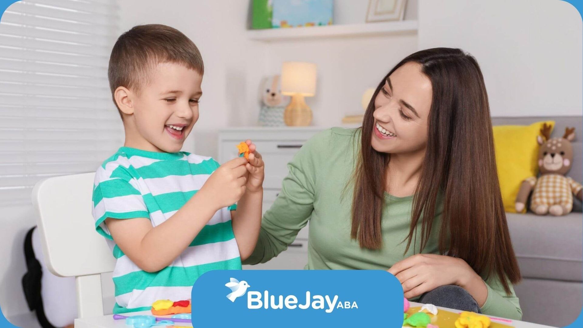 An ABA therapist and a boy are playing with play dough at a table in ABA therapy.