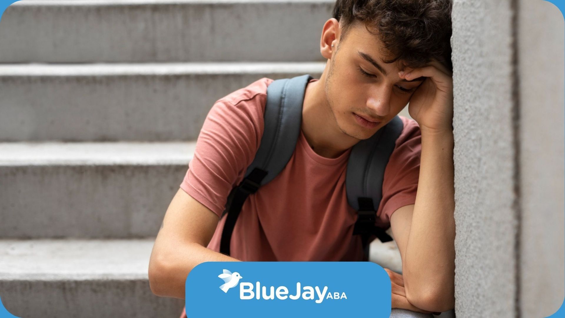 A young autistic man with a backpack is sitting on a set of stairs.