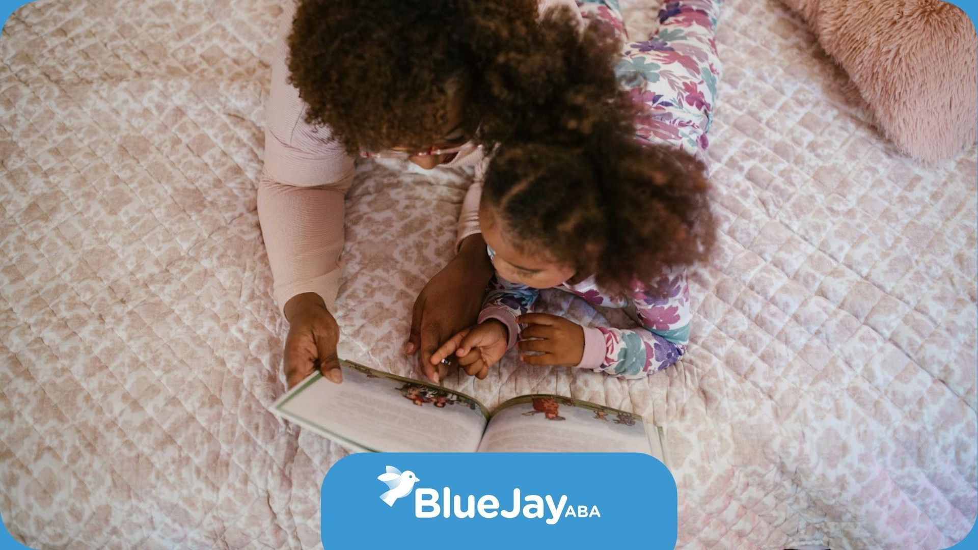 RBT and autistic  child lying on bed reading a storybook together during in-home ABA therapy in NC.