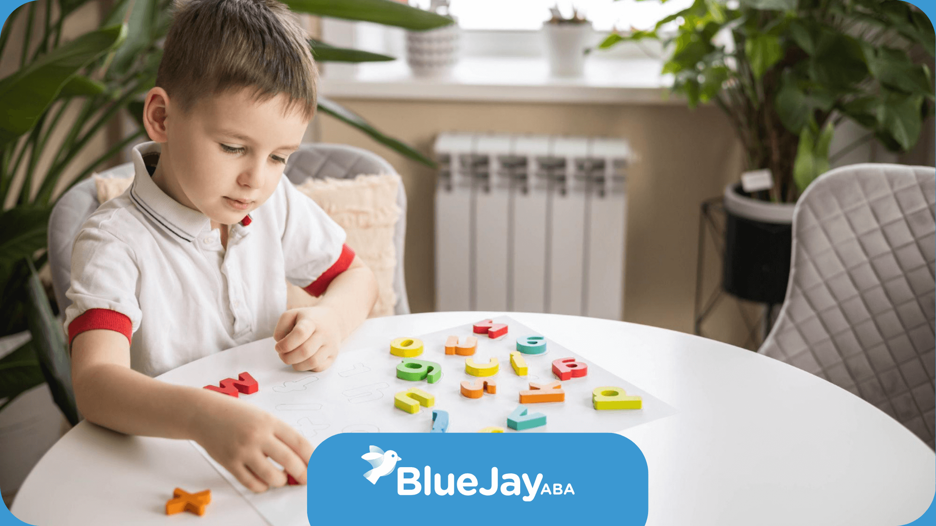 A young boy is sitting at a table playing with letters and numbers in ABA therapy.