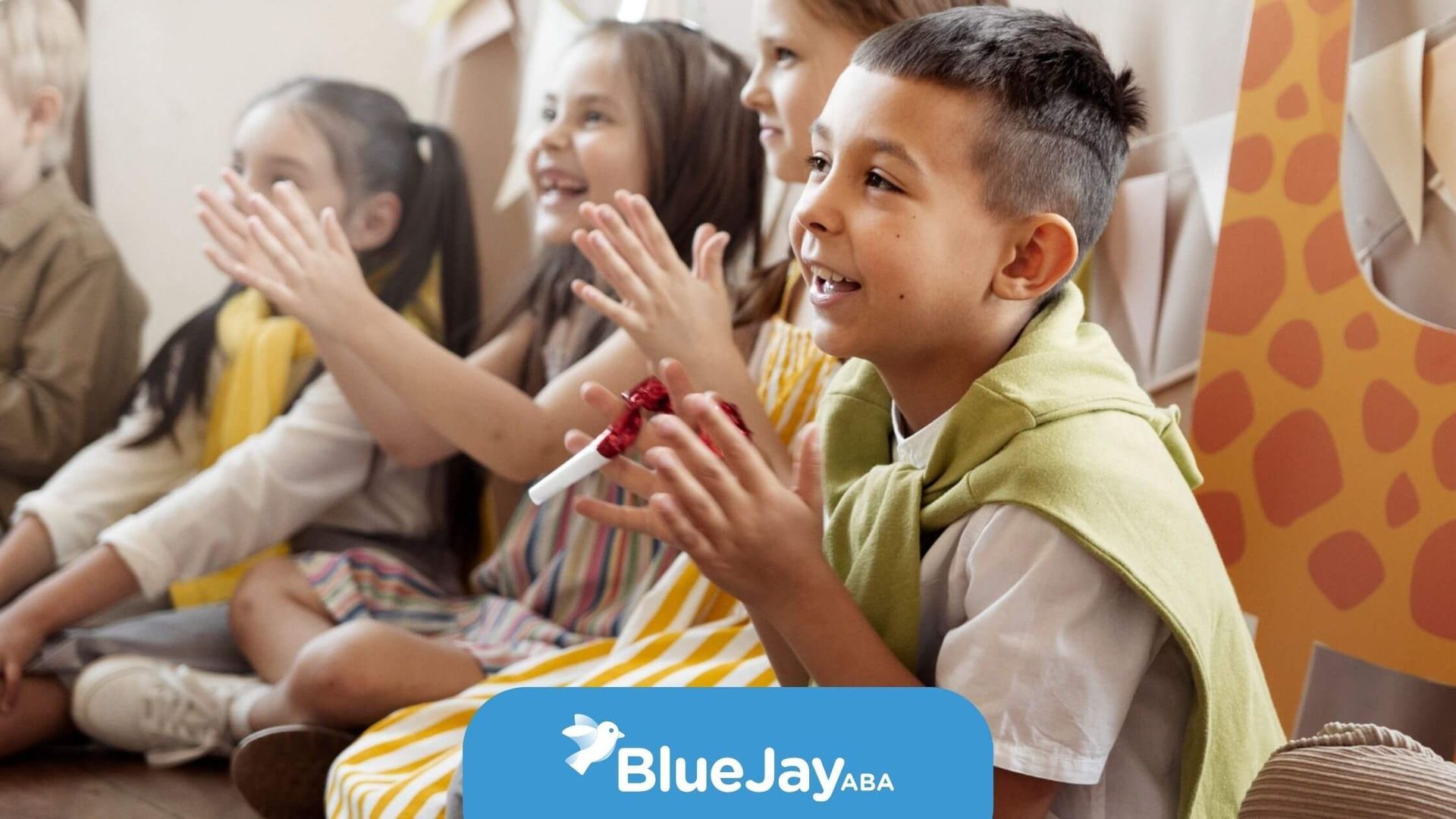 Group of children with autism sitting together and clapping during ABA therapy.