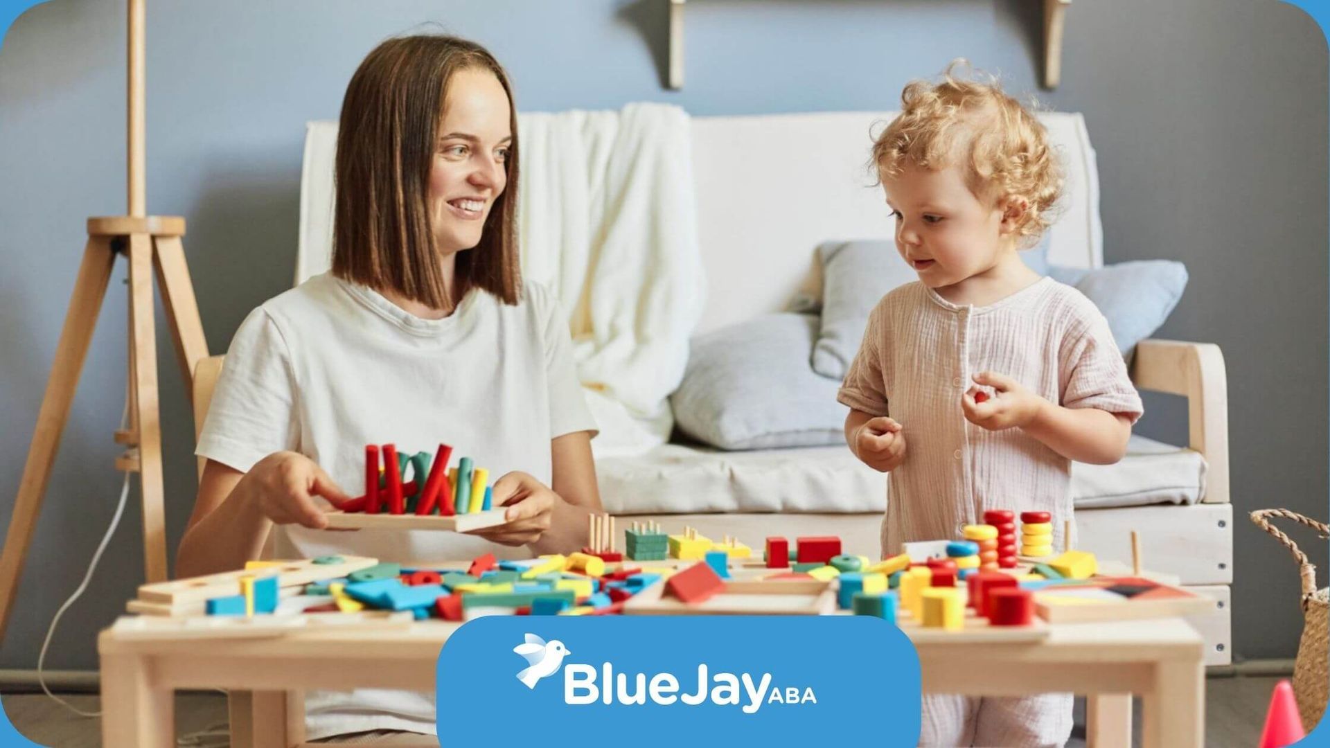 An ABA therapist and a child are playing with toys at a table in in-home ABA therapy.
