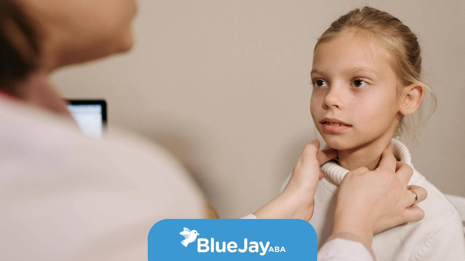 Female therapist examining an autistic young girl’s neck during a medical checkup in North Carolina.