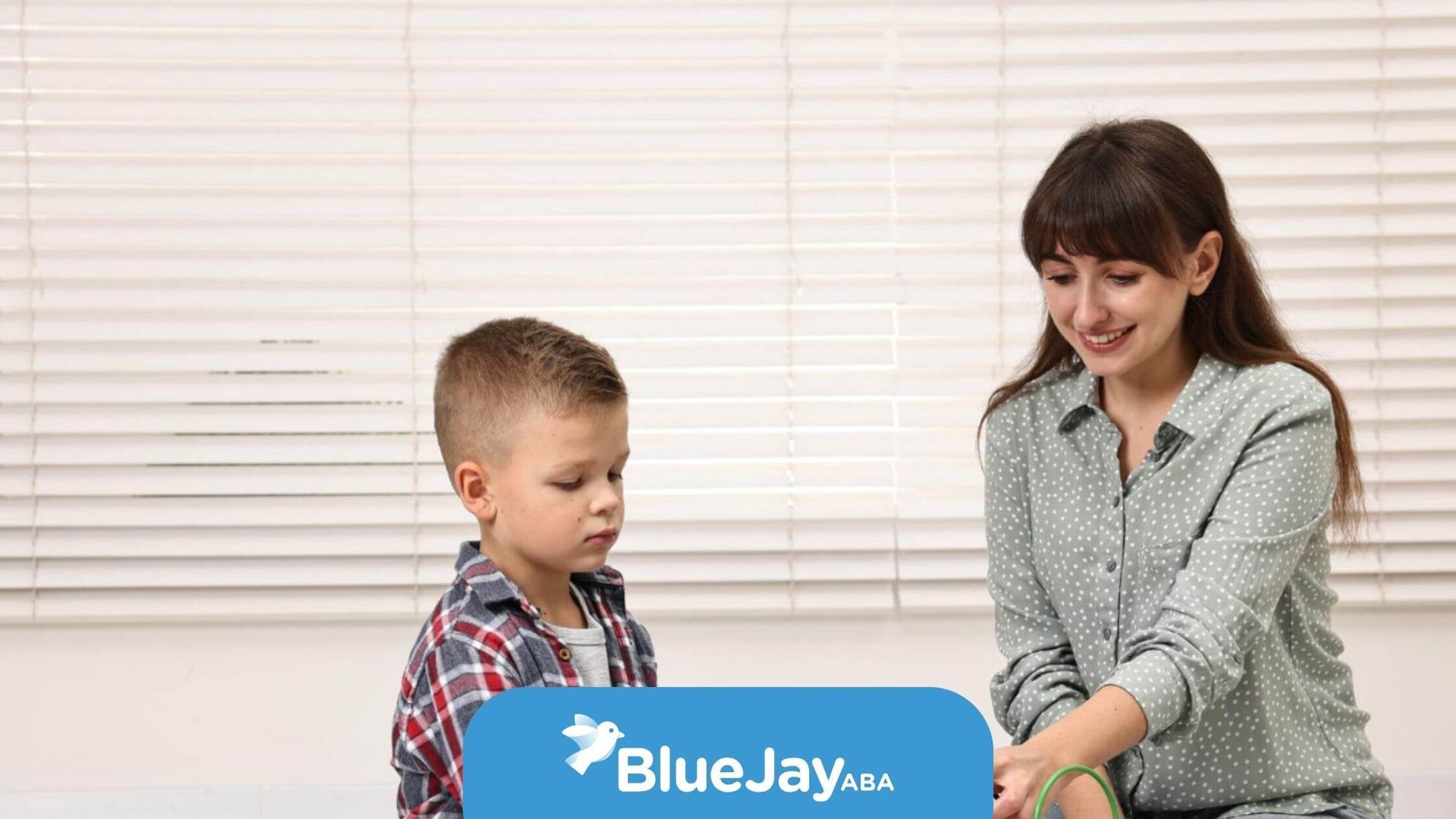 ABA therapist helping child with fine motor skills activity.