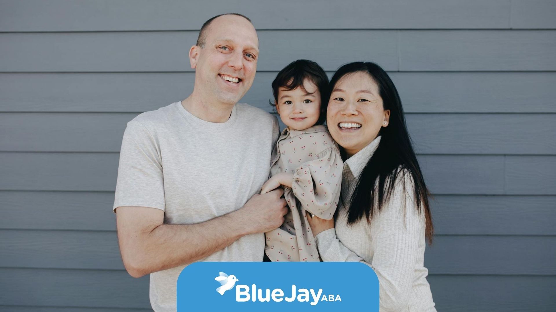Smiling family of three with two autistic parents and a neurotypical child posing outdoors in NC.