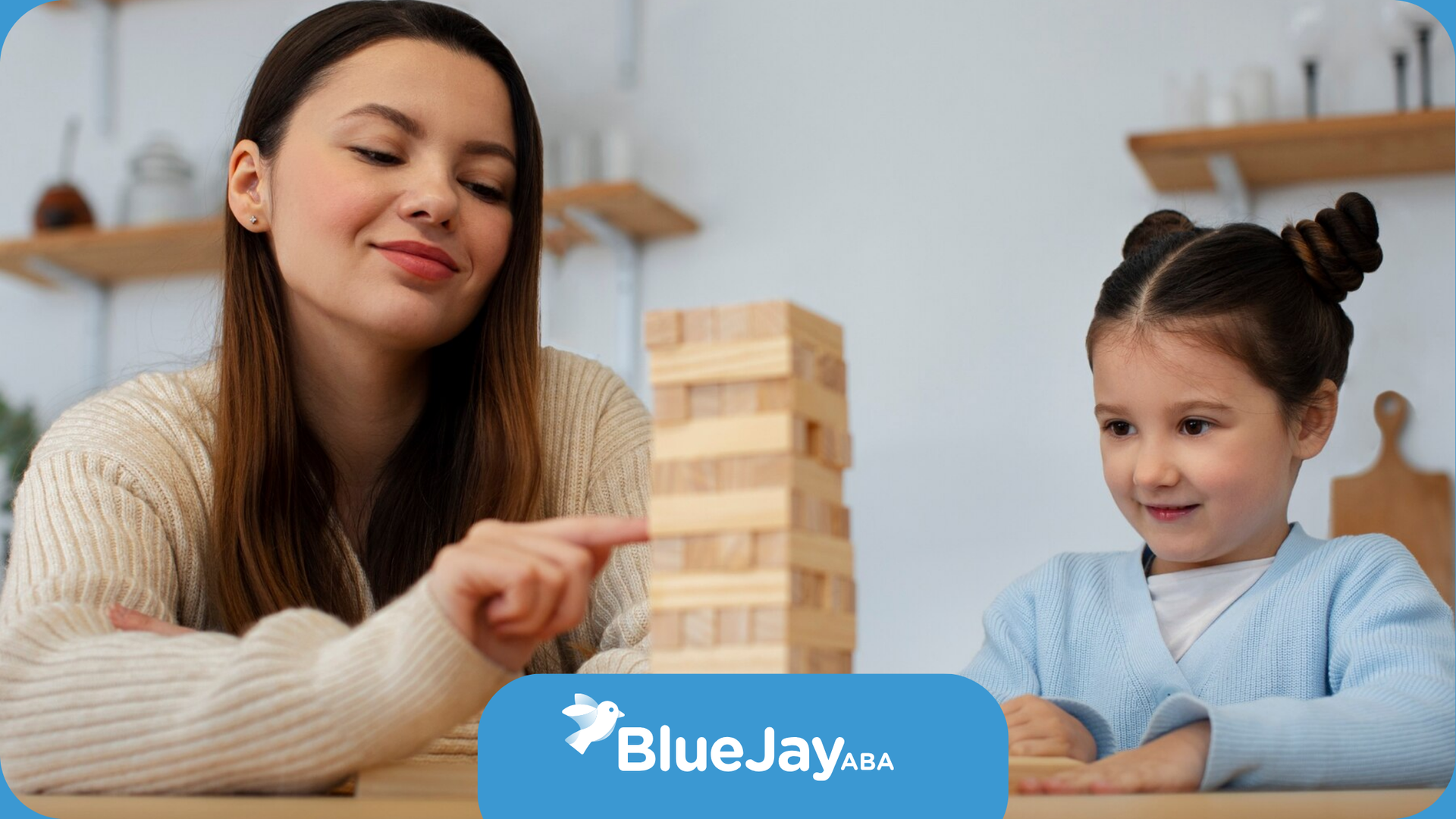 A girl with autism and her RBT are playing a game of Jenga.