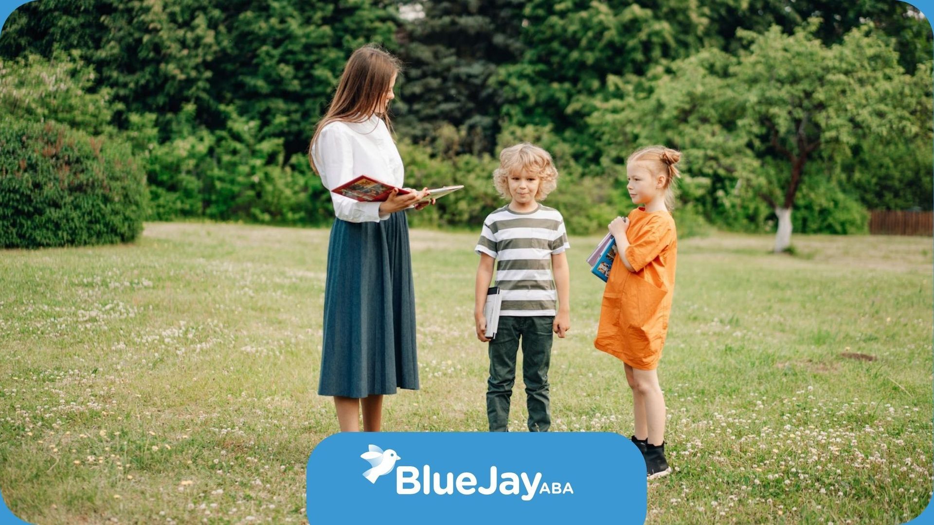 An ABA therapist teaching two autistic children outdoors in a grassy area during ABA therapy in NC.