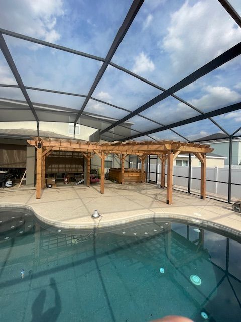 A swimming pool with a clear roof and a wooden pergola