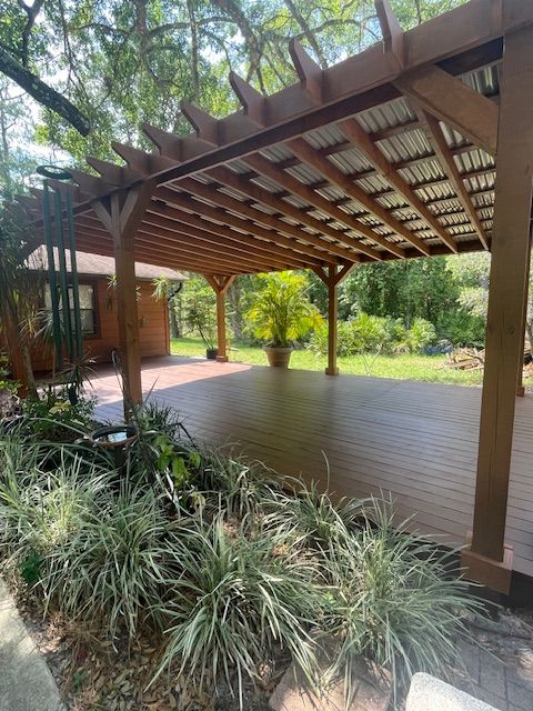 A large wooden deck with a pergola over it