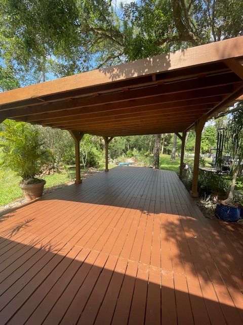 A large wooden deck with a covered area underneath it.