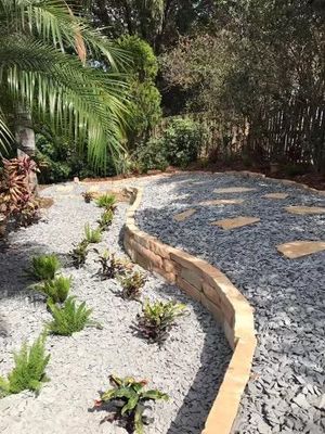 A garden with a brick walkway surrounded by gravel and plants.