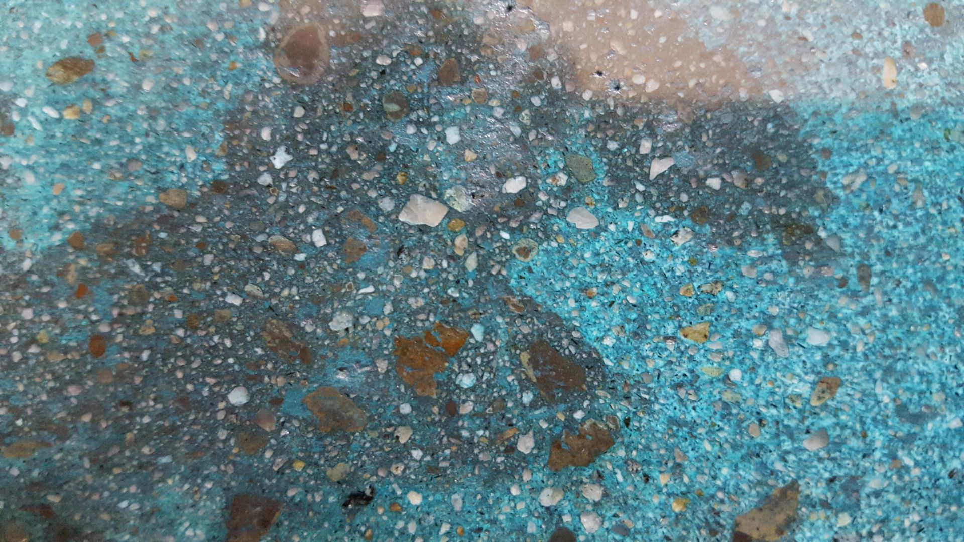 A close up of a blue surface with a lot of small rocks on it.