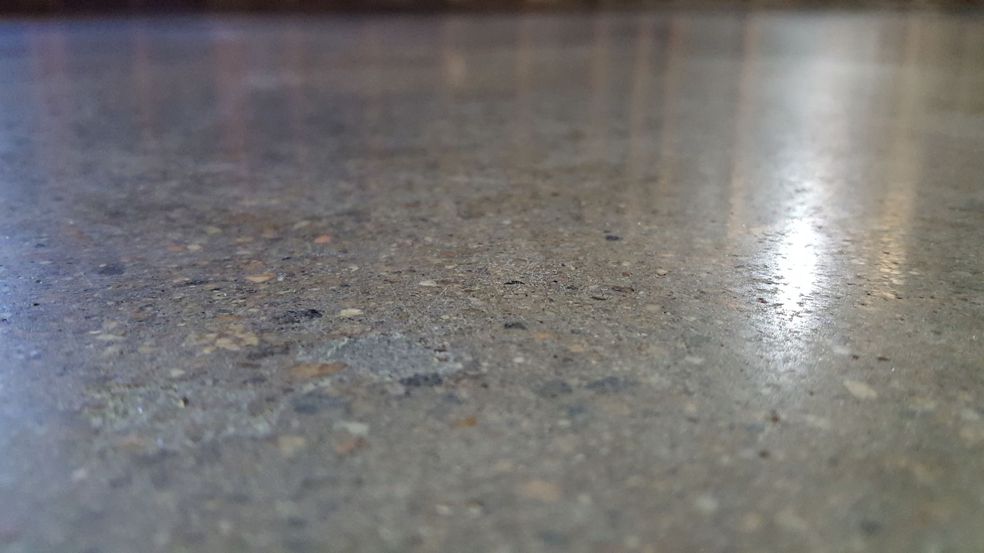 A close up of a concrete floor with a lot of small stones on it.
